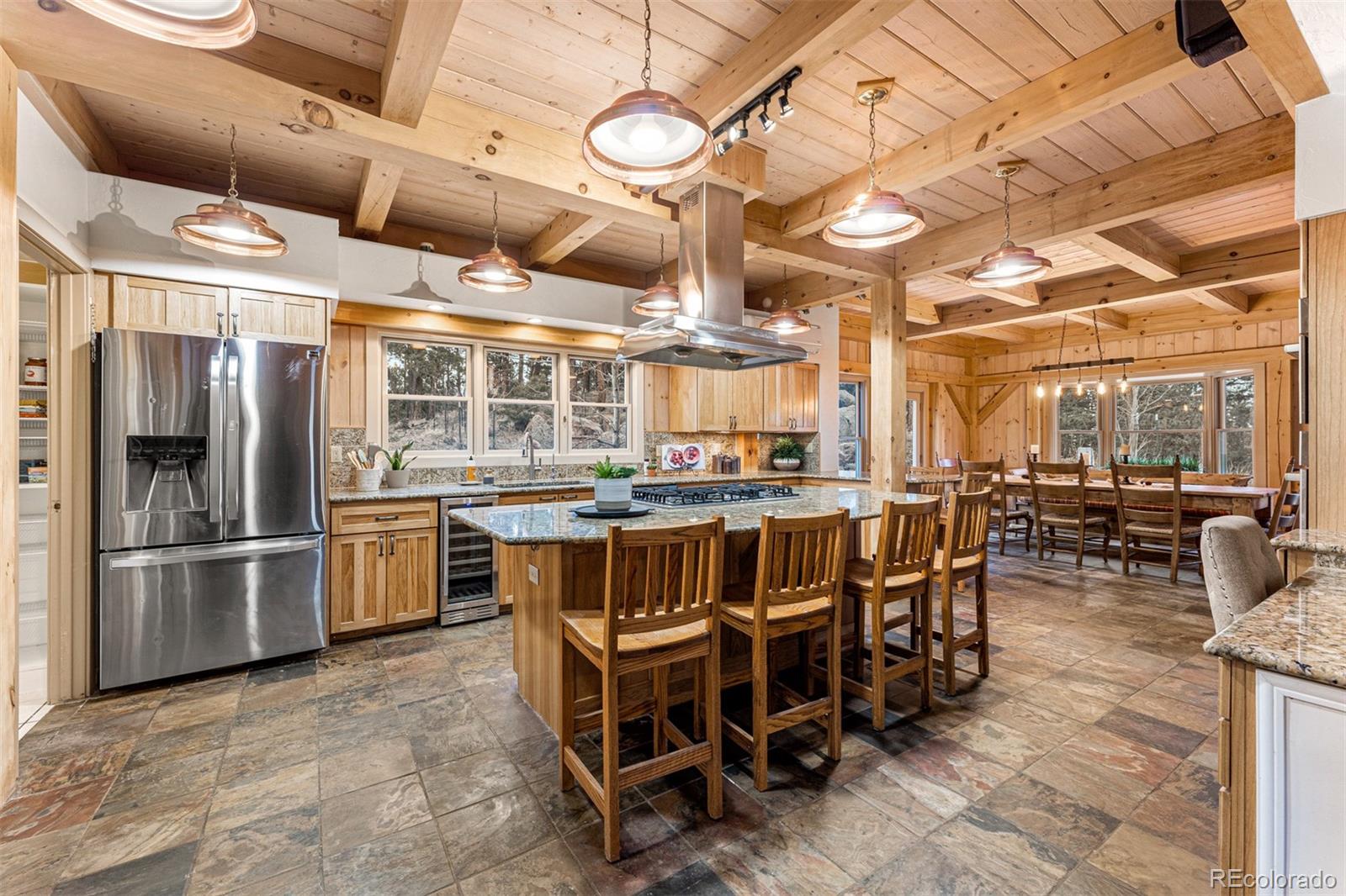 1057 Reed Ranch Road Boulder, CO 80302 - Photo 15 of 40 a kitchen with lots of wooden furniture and stainless steel appliances