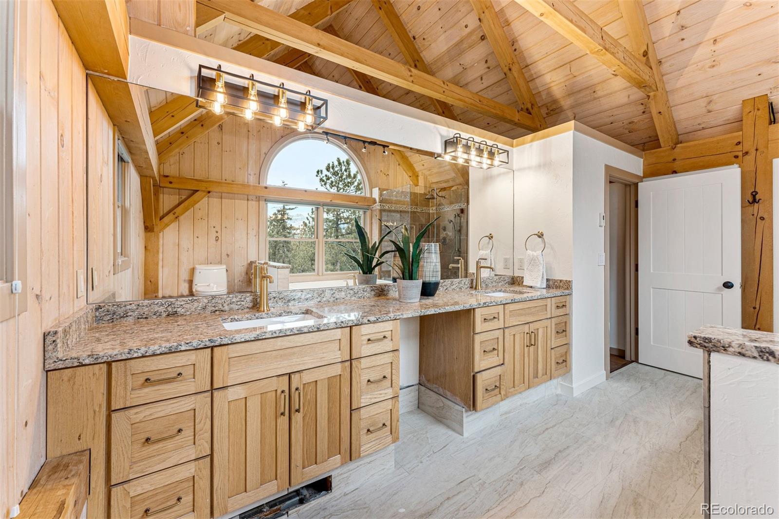 1057 Reed Ranch Road Boulder, CO 80302 - Photo 27 of 40 a spacious bathroom with a granite countertop sink mirror and a shower