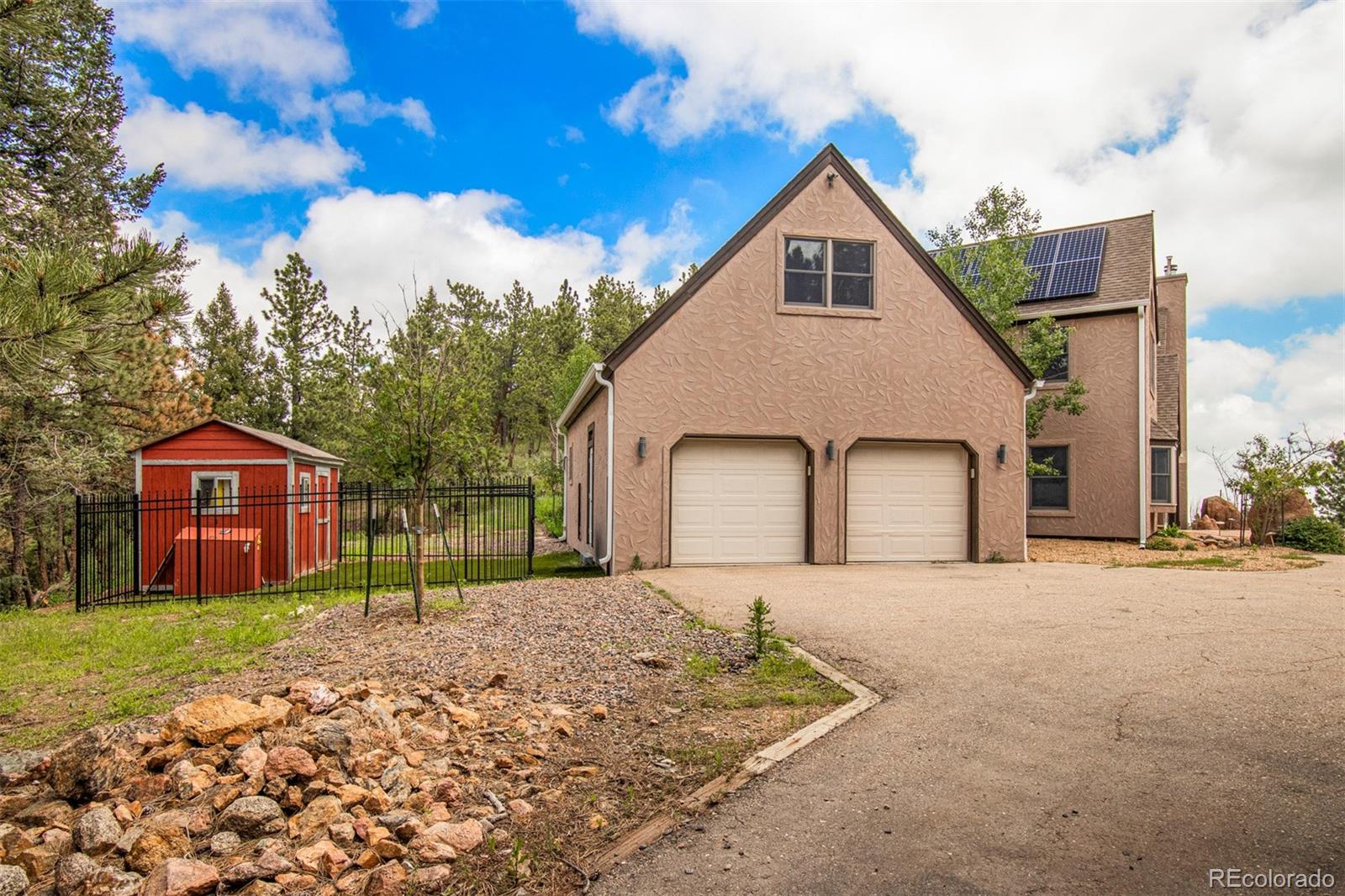 1057 Reed Ranch Road Boulder, CO 80302 - Photo 37 of 40 a front view of a house with a yard and garage