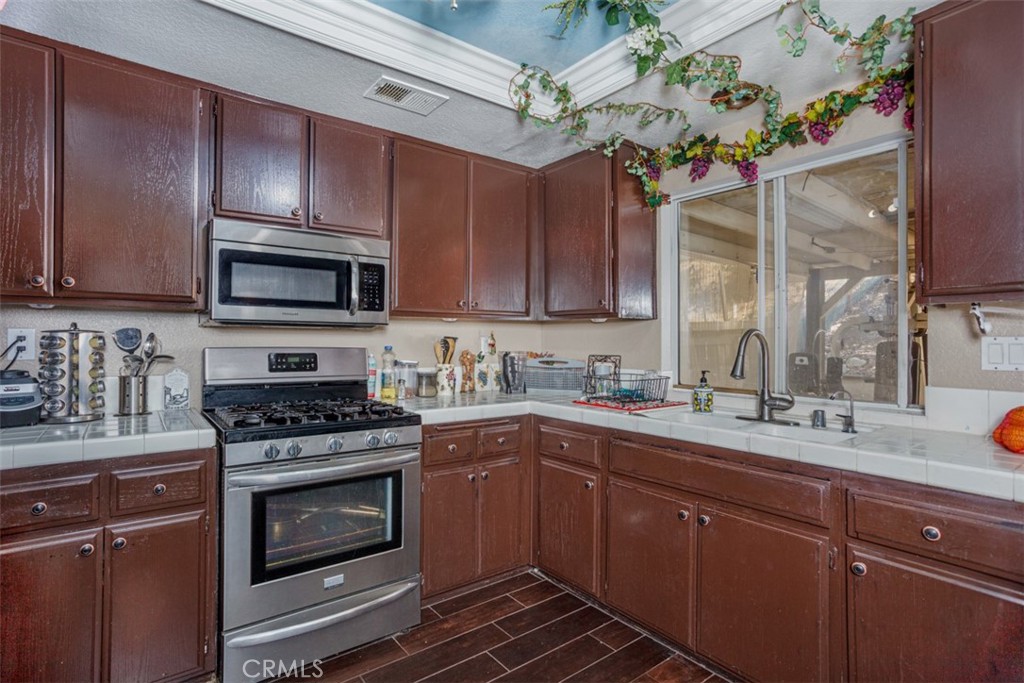 13365 Cloudburst Drive Corona, CA 92883 - Photo 3 of 21 a kitchen with a sink stove and microwave