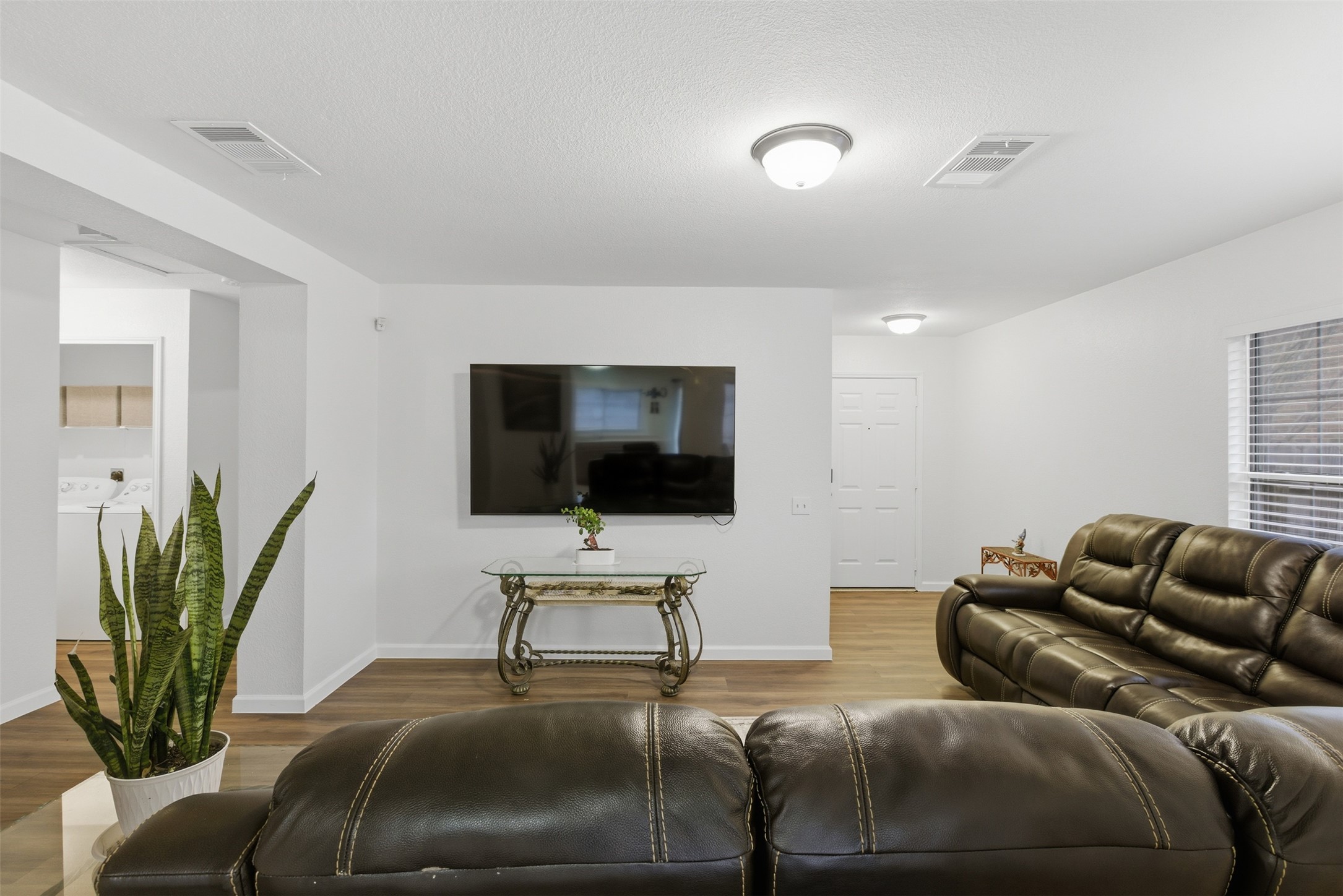 7536 Marble Ridge Drive Austin, TX 78747 - Photo 14 of 30 Living area featuring wood finished floors, washing machine and dryer, and a textured ceiling