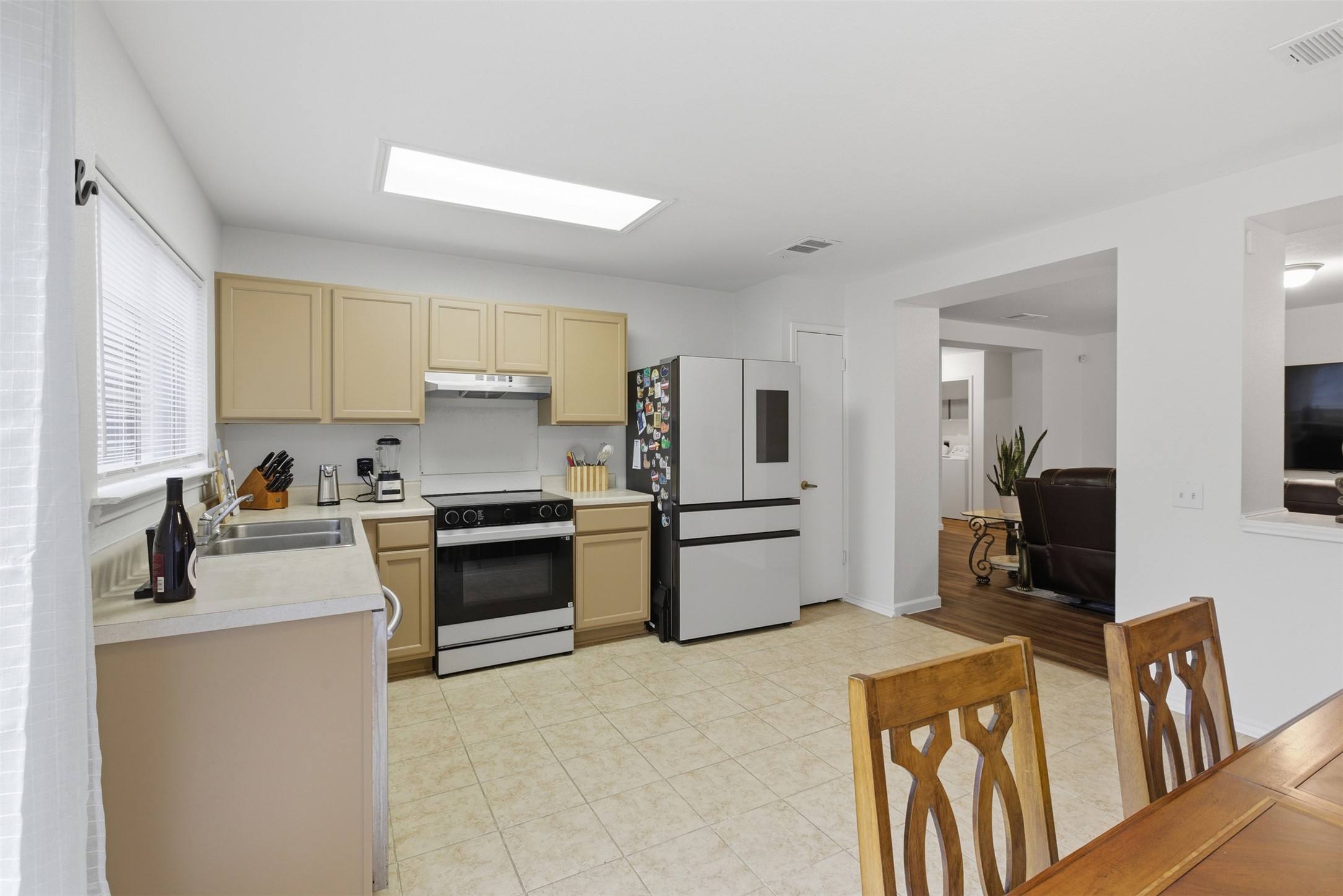 7536 Marble Ridge Drive Austin, TX 78747 - Photo 18 of 30 Kitchen with light countertops, freestanding refrigerator, range with electric stovetop, under cabinet range hood, and light brown cabinets