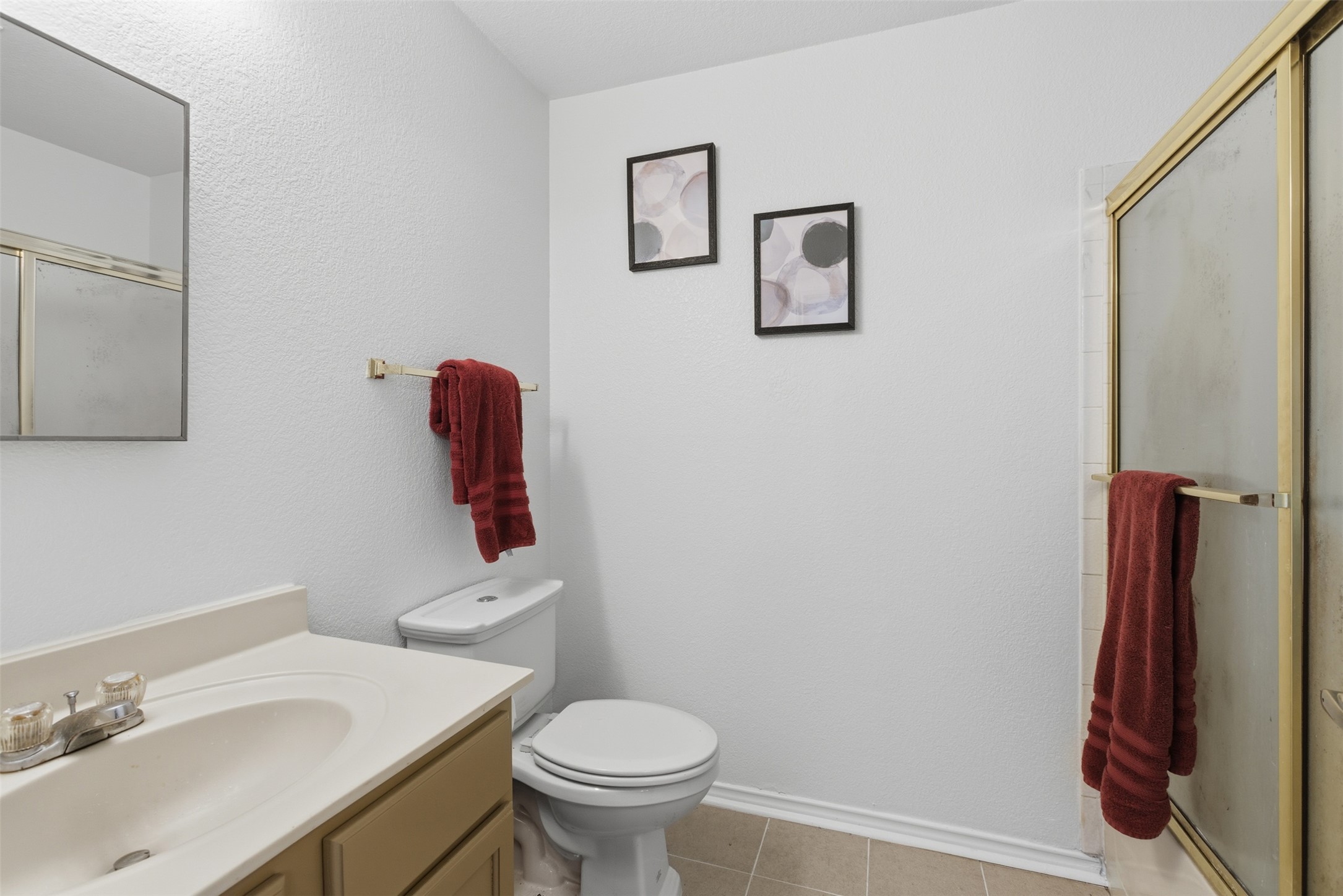 7536 Marble Ridge Drive Austin, TX 78747 - Photo 22 of 30 Bathroom with a shower stall, vanity, light tile patterned flooring, and a textured wall