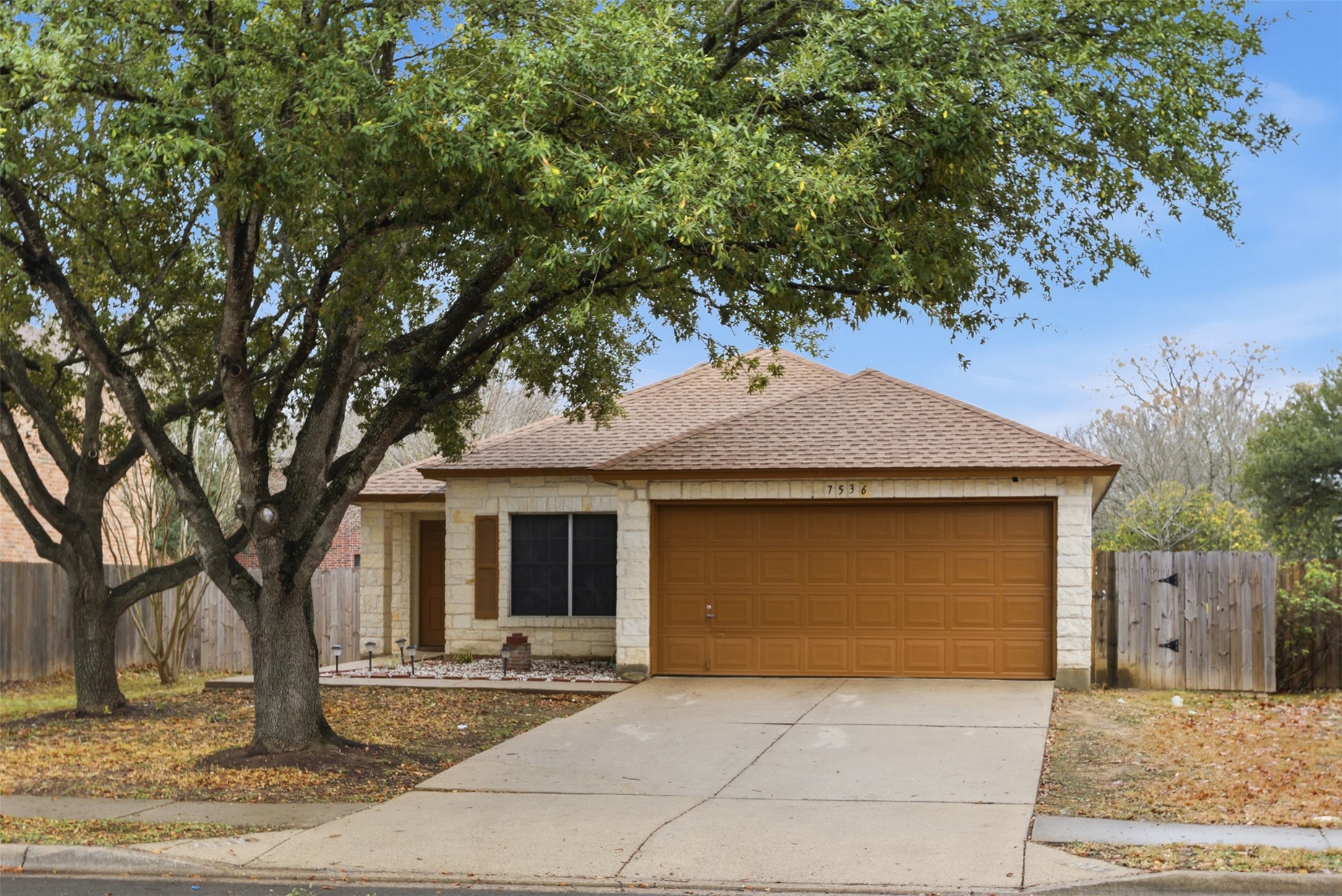 7536 Marble Ridge Drive Austin, TX 78747 - Photo 4 of 30 View of front of property with roof with shingles, driveway, an attached garage, and stone siding