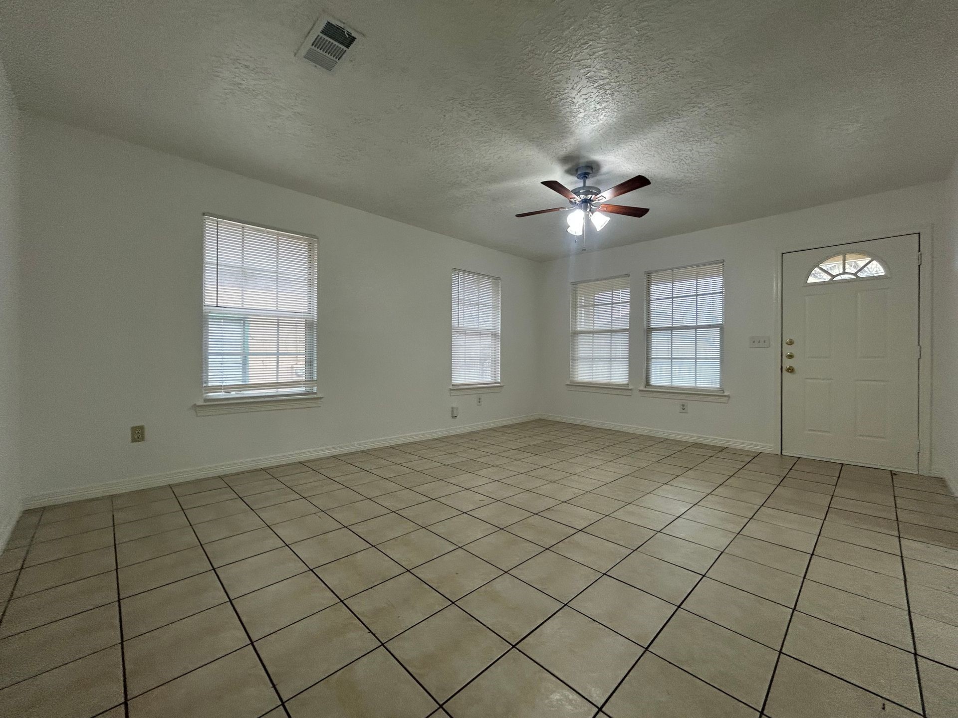 1614 Common Street Houston, TX 77009 - Photo 11 of 13 an empty room with chandelier fan and windows