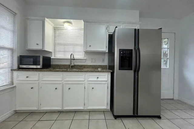 a kitchen with stainless steel appliances granite countertop a refrigerator and a stove