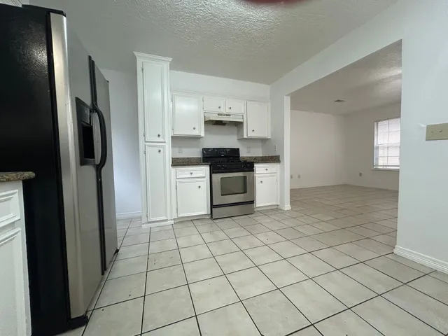 a kitchen with stainless steel appliances a refrigerator and a stove top oven