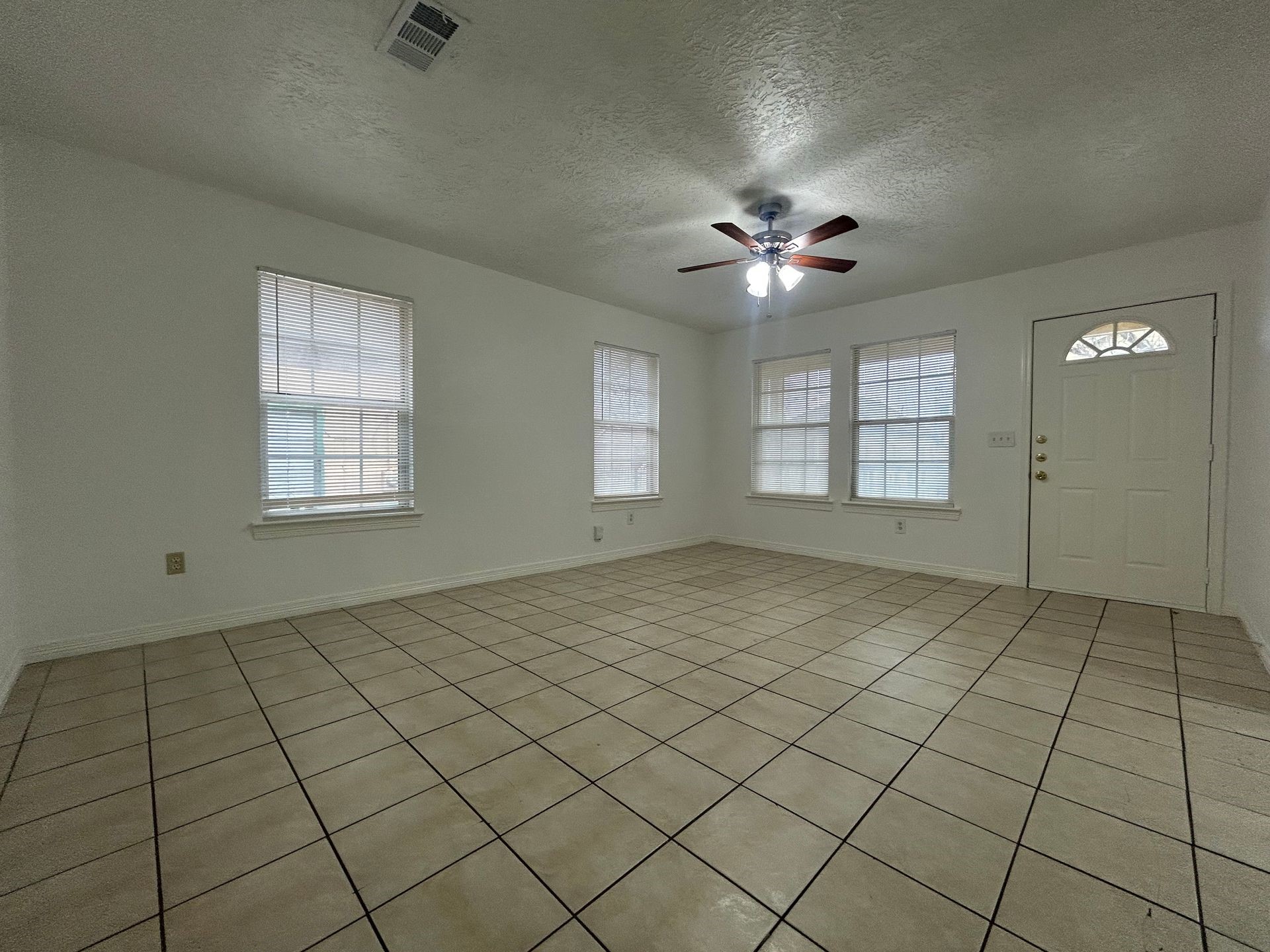 1614 Common Street Houston, TX 77009 - Photo 6 of 13 an empty room with chandelier fan and windows