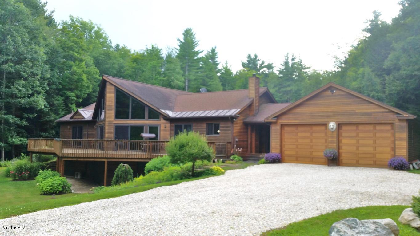 116 Otis Road Becket, MA 01223 - Photo 1 of 29 a front view of a house with a garden and plants
