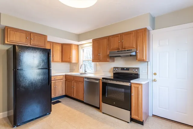 a kitchen with stainless steel appliances granite countertop a refrigerator stove and a sink