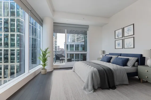 a bedroom with a bed couch and a large window