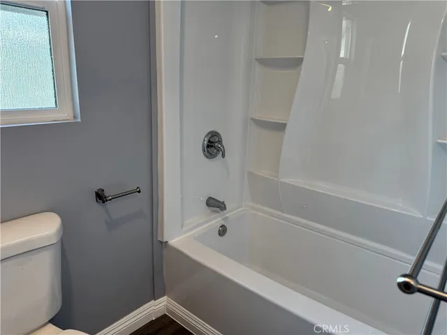 a white bath tub sitting next to a toilet