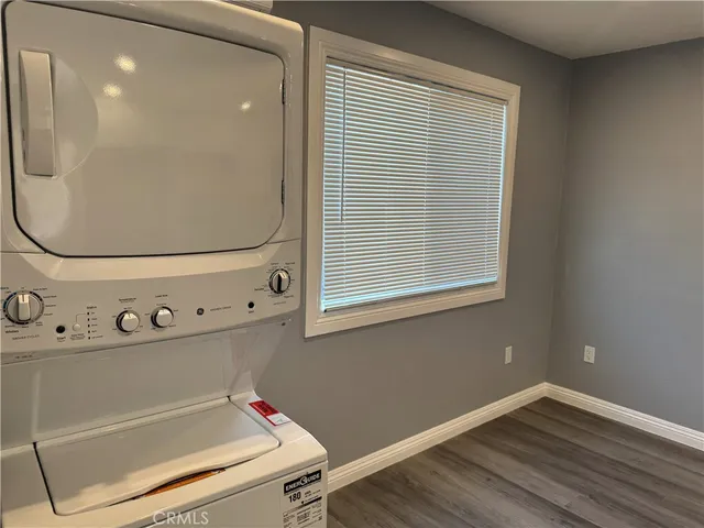 a utility room with wooden floor washer and dryer