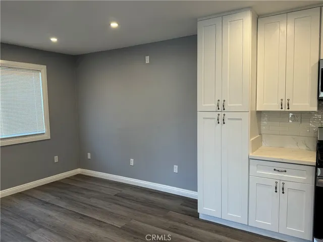 an empty room with wooden floor and window