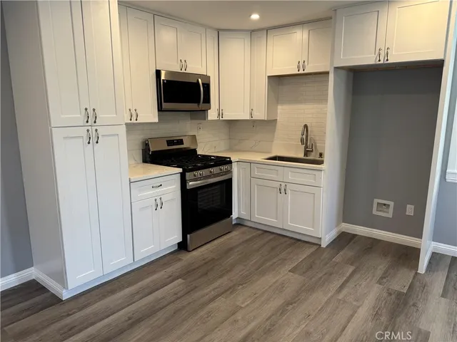 a kitchen with a sink a stove and cabinets