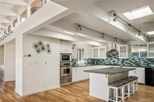 a kitchen with stainless steel appliances kitchen island granite countertop a refrigerator and a stove top oven