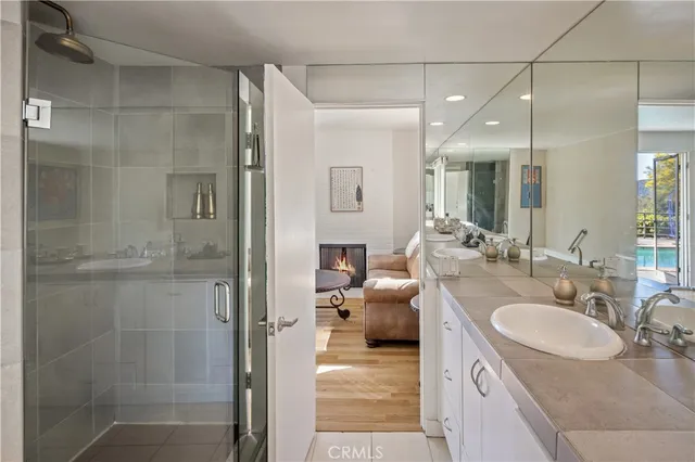 a en suite bathroom with a granite countertop sink a mirror and shower