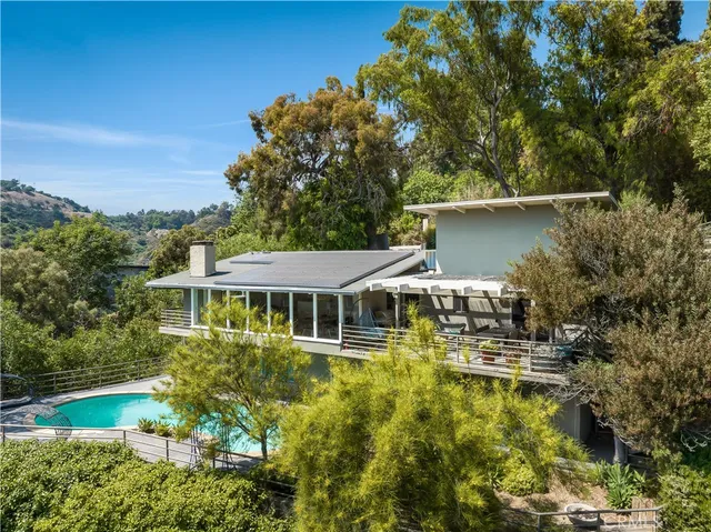 an aerial view of a house with swimming pool outdoor seating and yard