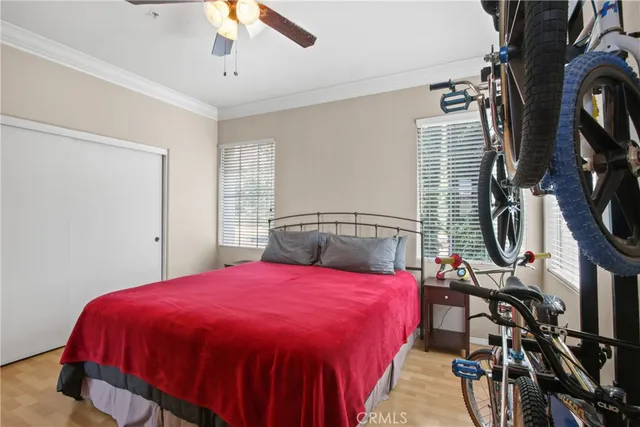 a bedroom with a bed a flat screen tv and a chandelier