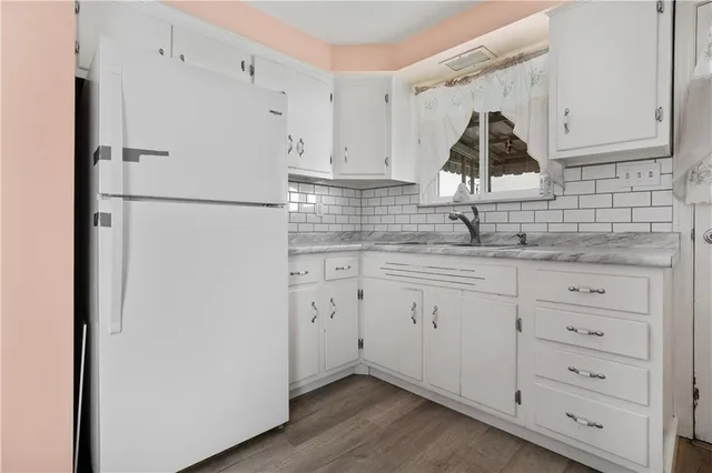 a kitchen with white cabinets and refrigerator