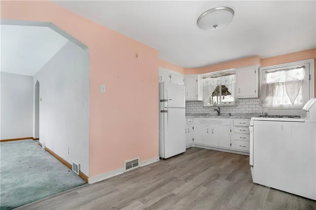 a kitchen with granite countertop white cabinets and white appliances