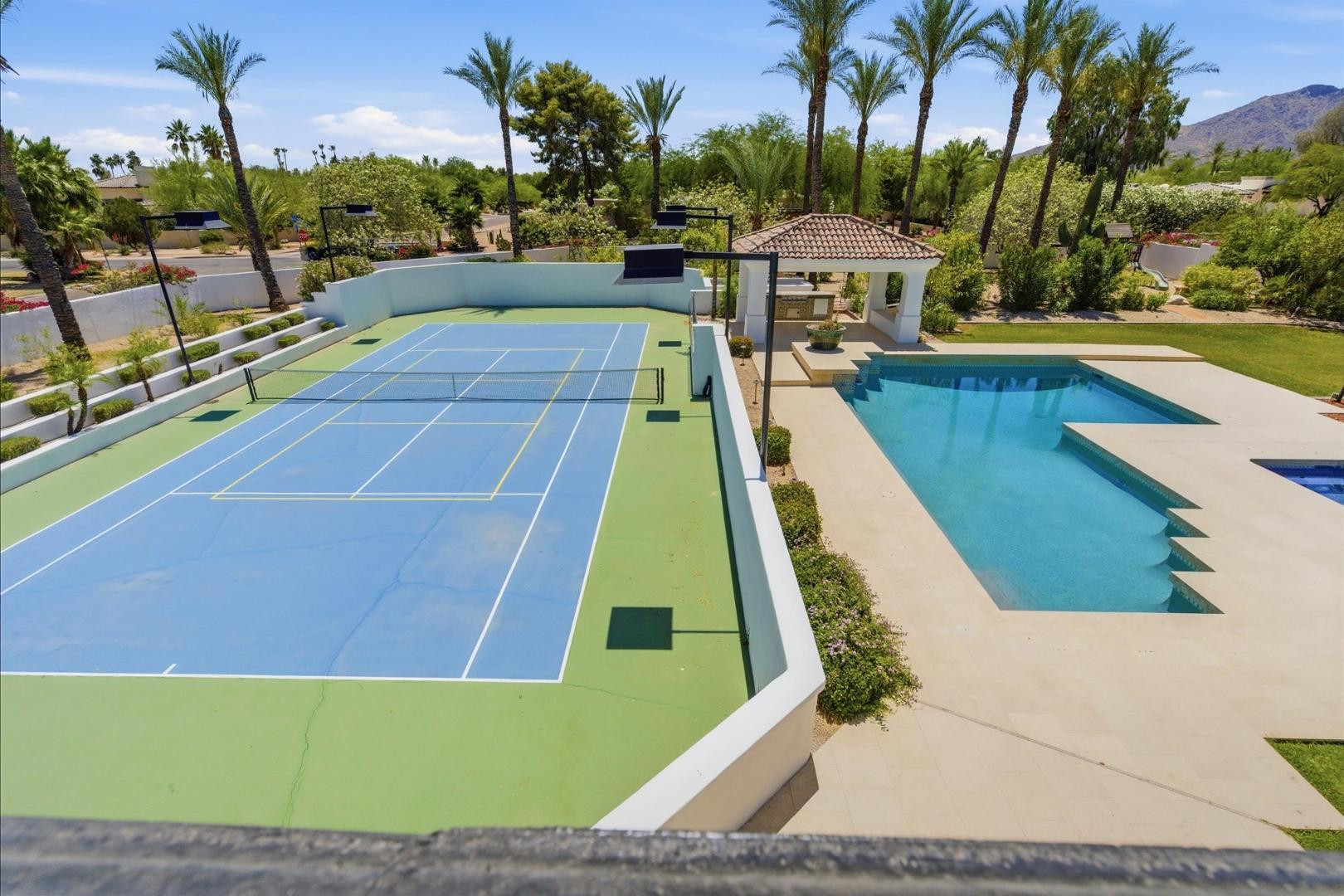 6997 East Paradise Ranch Road Paradise Valley, AZ 85253 - Photo 15 of 17 a view of a swimming pool with a yard and palm trees