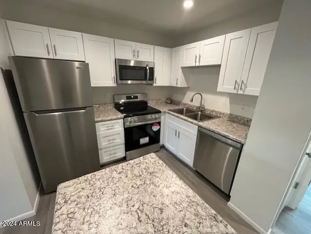 a kitchen with stainless steel appliances granite countertop a refrigerator stove top oven a sink and dishwasher