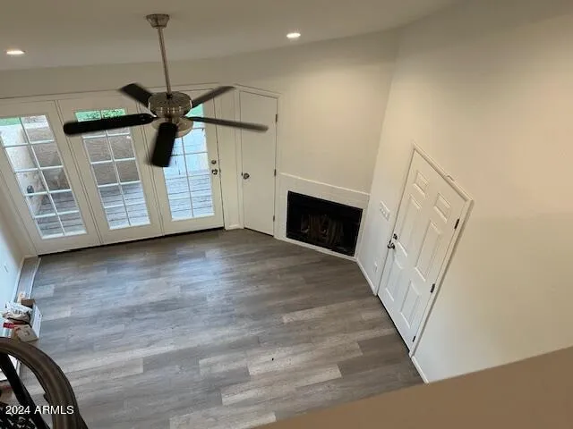 a view of a livingroom with wooden floor fireplace and a window