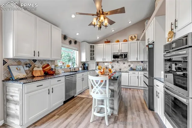 a kitchen with white cabinets and stainless steel appliances