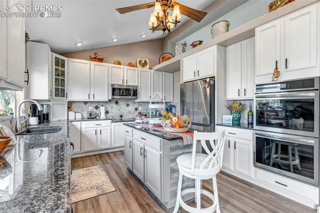 a kitchen with stainless steel appliances a stove refrigerator sink and cabinets