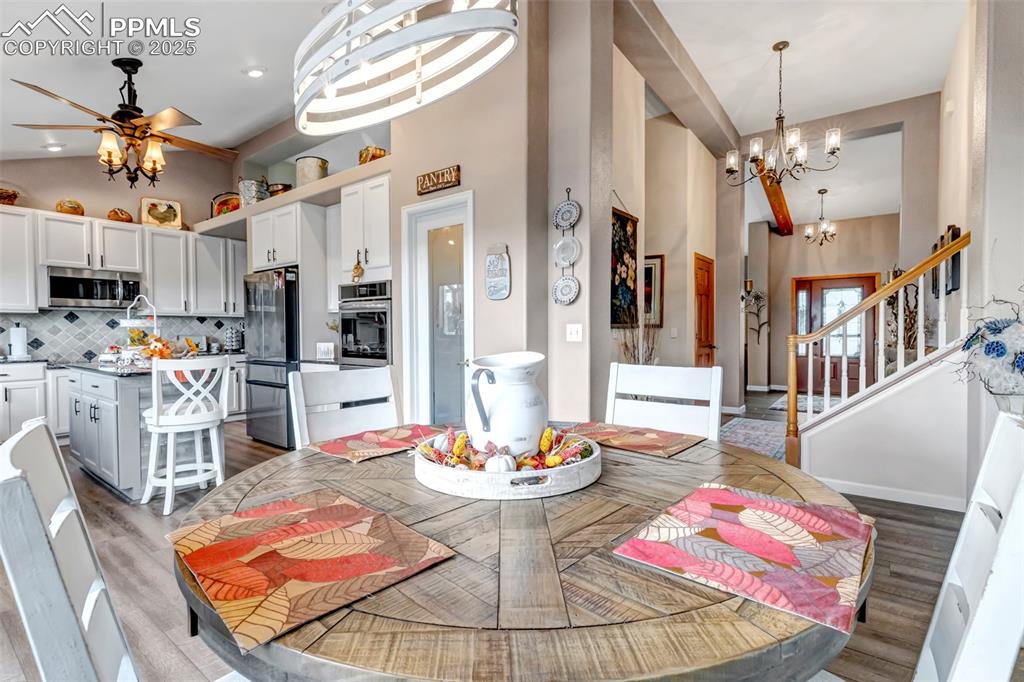 7120 Highcroft Drive Colorado Springs, CO 80922 - Photo 17 of 50 a dining room with wooden floor a chandelier a wooden table and chairs
