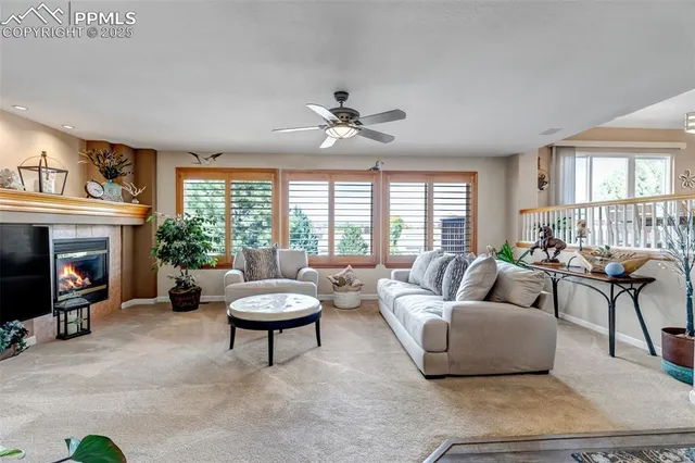 a living room with furniture a fireplace and a large window