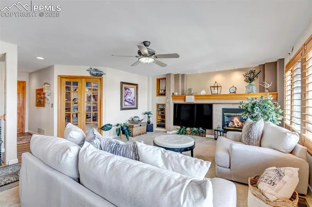 a living room with furniture a fireplace and a large window