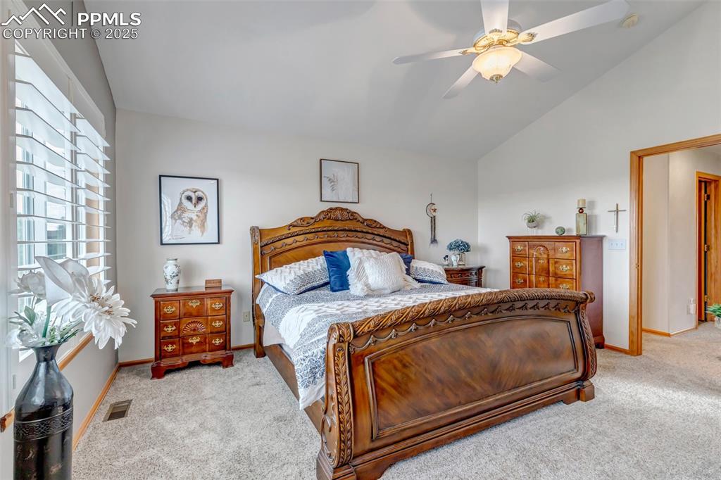 7120 Highcroft Drive Colorado Springs, CO 80922 - Photo 26 of 50 a bedroom with a bed and a chandelier