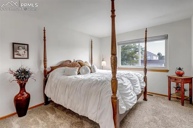 a bed sitting in a bedroom next to a window