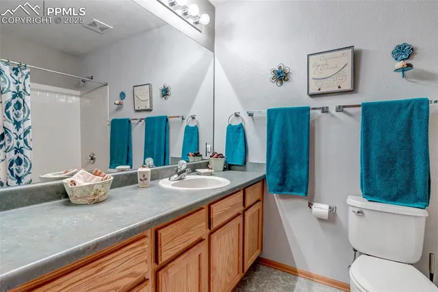 a bathroom with a granite countertop sink mirror vanity and toilet