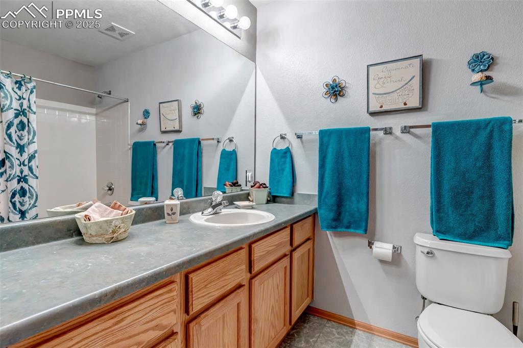 7120 Highcroft Drive Colorado Springs, CO 80922 - Photo 37 of 50 a bathroom with a granite countertop sink mirror vanity and toilet