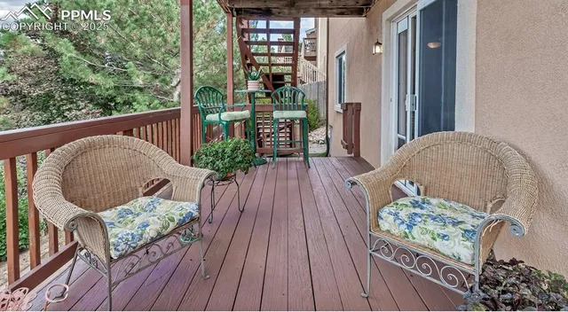 a balcony with wooden floor table and chairs