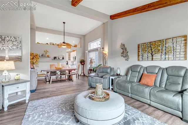 a living room with furniture kitchen view and a large window