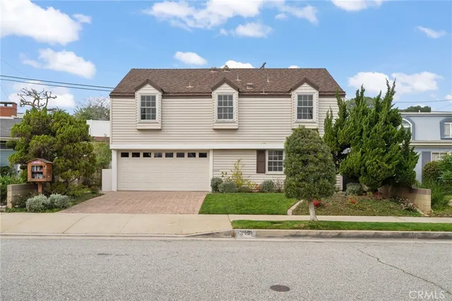a front view of a house with a garden and plants