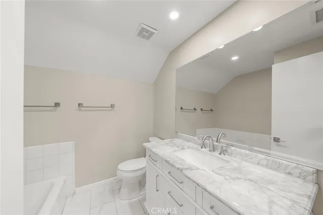 a bathroom with a granite countertop sink a toilet and a shower