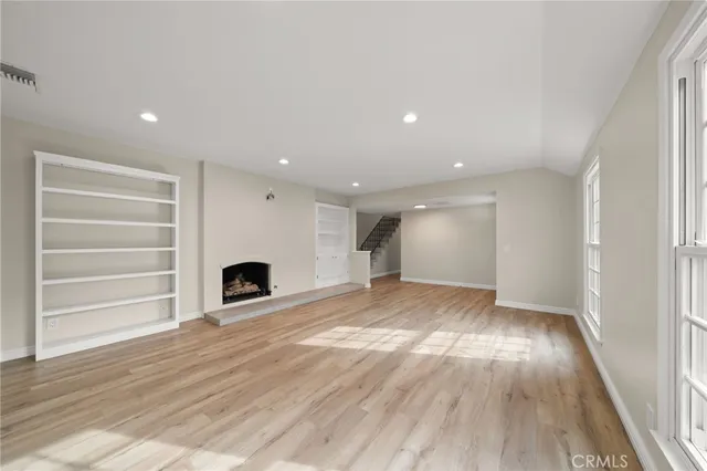 a view of empty room with wooden floor and fireplace