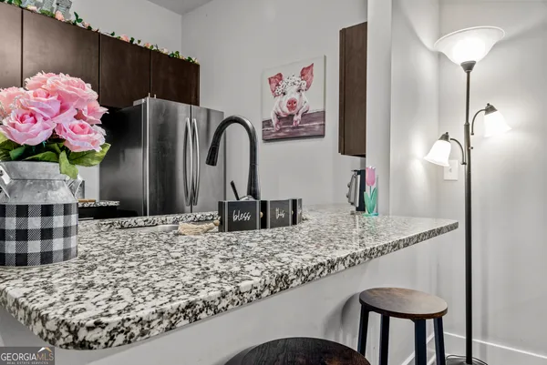 a bathroom with a granite countertop sink a mirror and shower