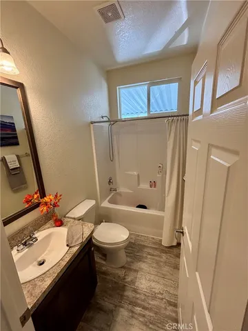 a bedroom with a bed and a flat tv screen on dresser