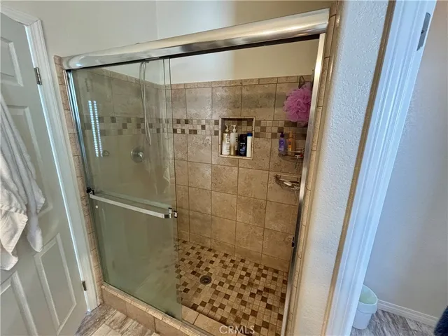a bathroom with a granite countertop double vanity sink and mirror