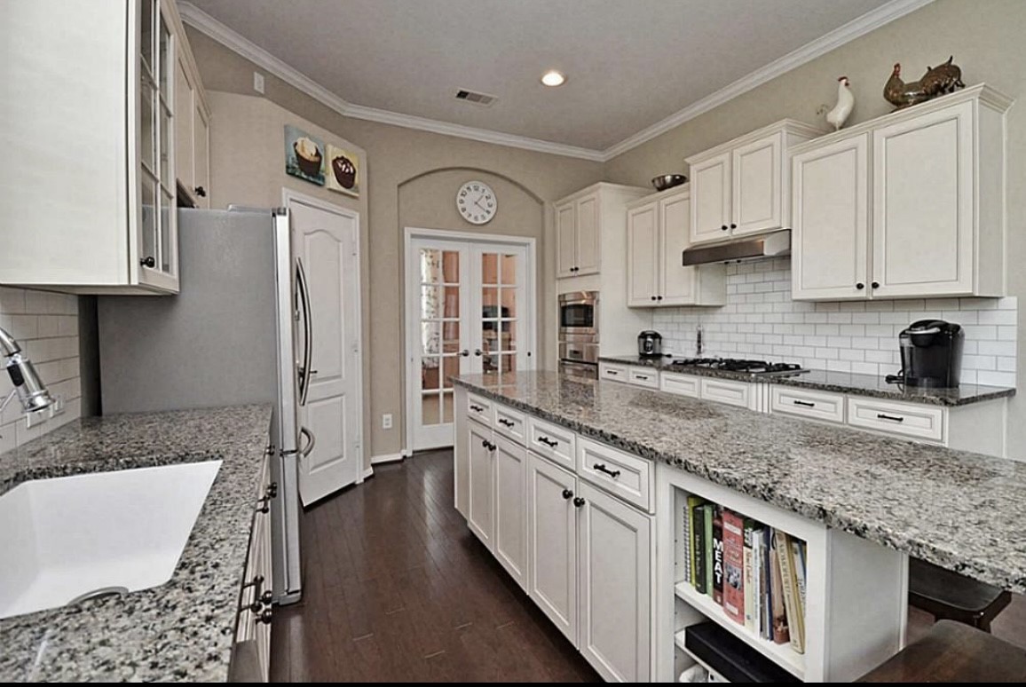 1447 Ralston Branch Way Sugar Land, TX 77479 - Photo 7 of 21 It’s easy to picture breezing through culinary endeavors in this kitchen, with its expansive island, abundant cabinetry and ample countertop space. The bar seating is a charming feature, for both lively meal prep and conversation.