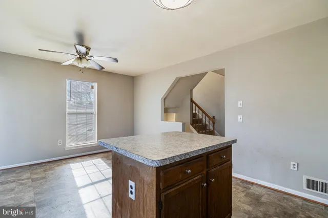 an entryway with chandelier fan and wooden floor