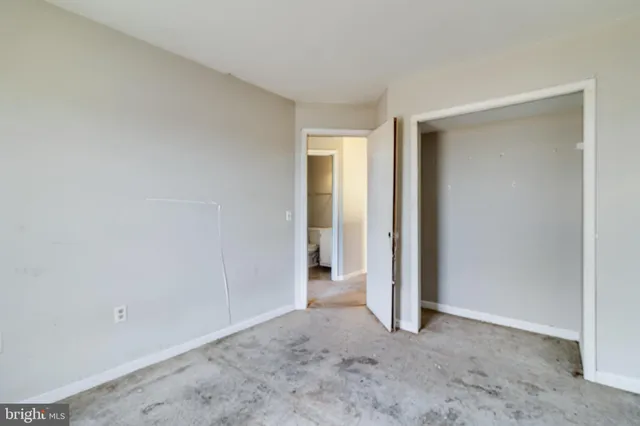 an empty room with closet and a bathroom
