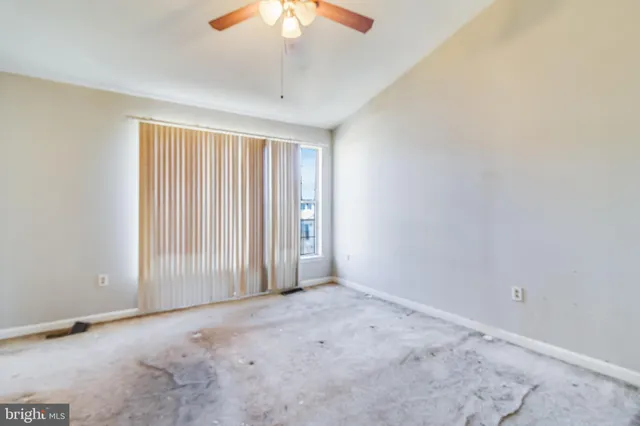 an empty room with a chandelier fan