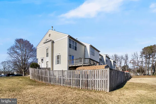 a view of a white house with wooden fence
